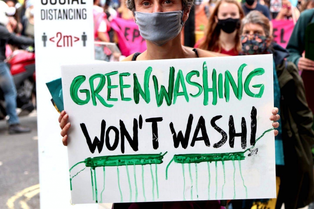 Demonstrator Holding Sign Saying Greenwashing Won't Wash